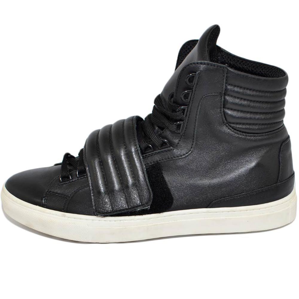 Sneakers alta sono nera in vera pelle con strappo laterale ganci e borchie moda street fondo bianco moda giovane.